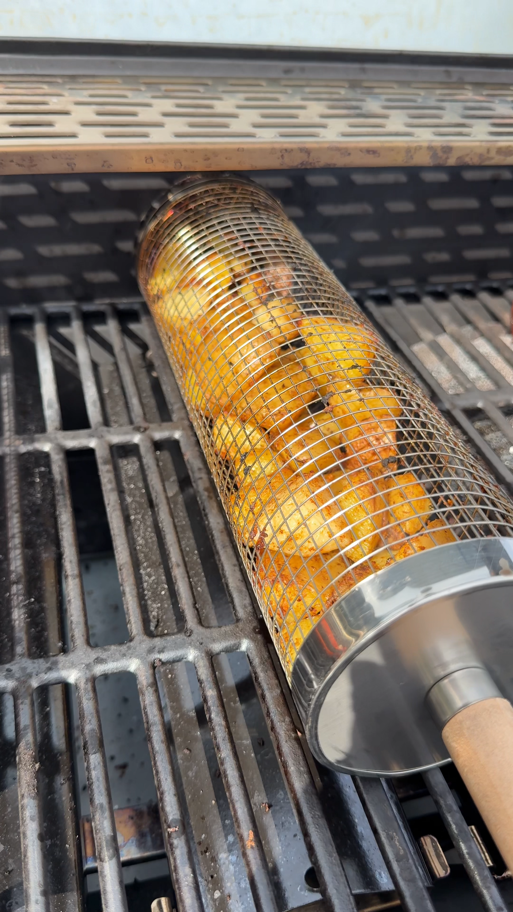 A cylindrical basket cooking corn and smaller ingredients