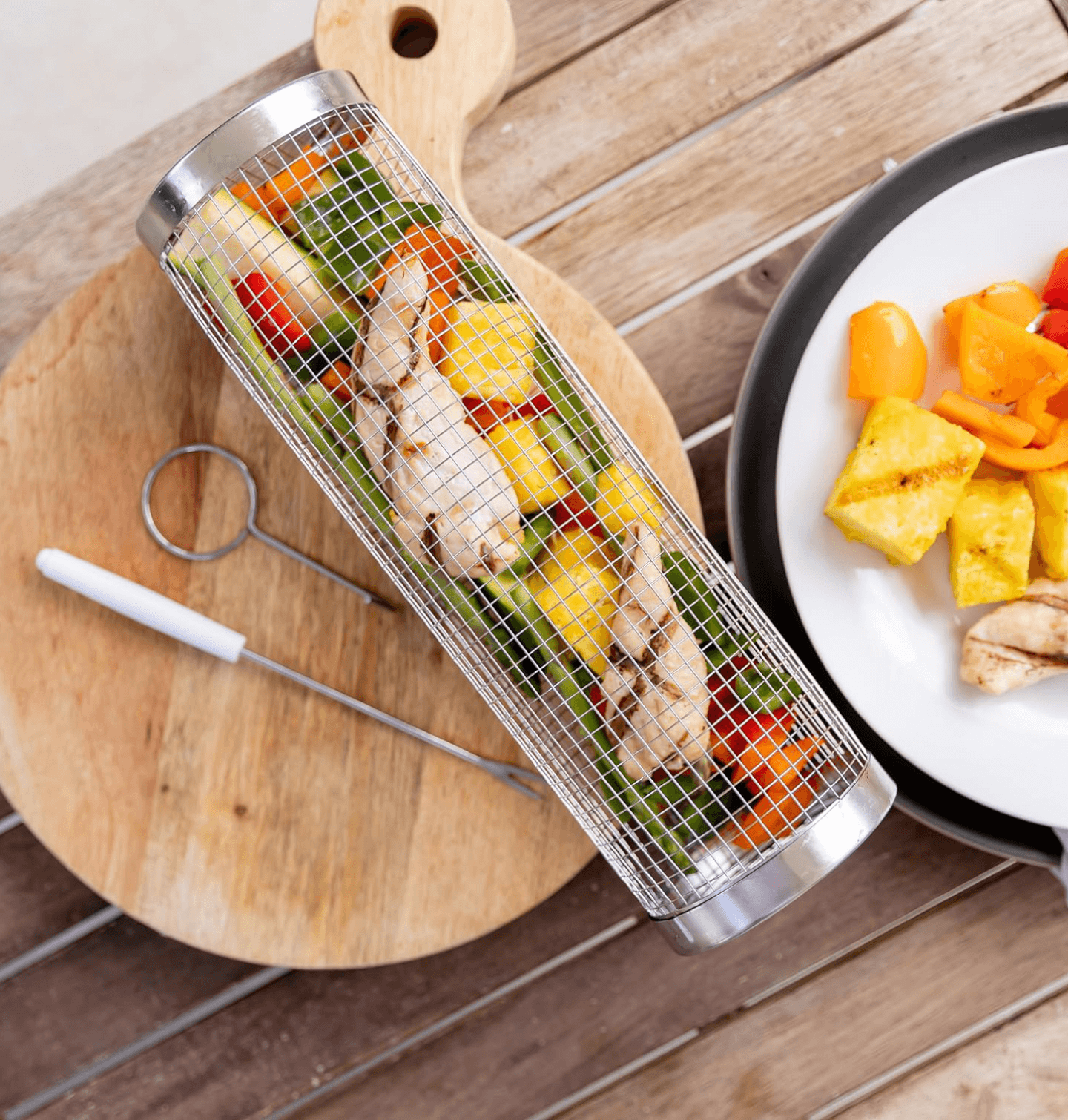 Bryn grill basket on cutting board with grilled vegetables
